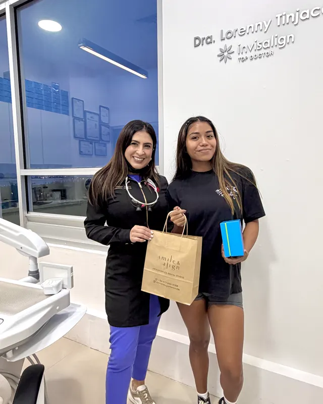 La doctora y una paciente con su bolsa de Smile & Align y su caja de Invisalign