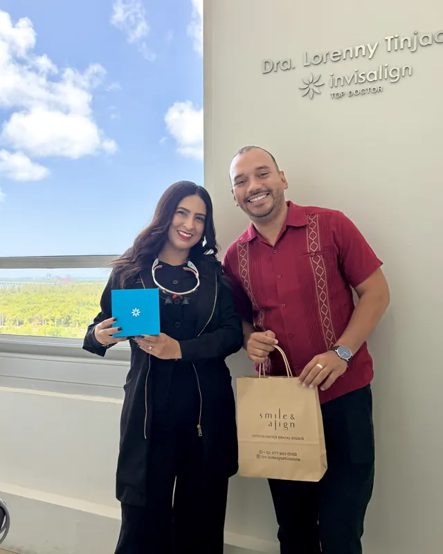 Un paciente recibe su caja de Invisalign de manos de la doctora
