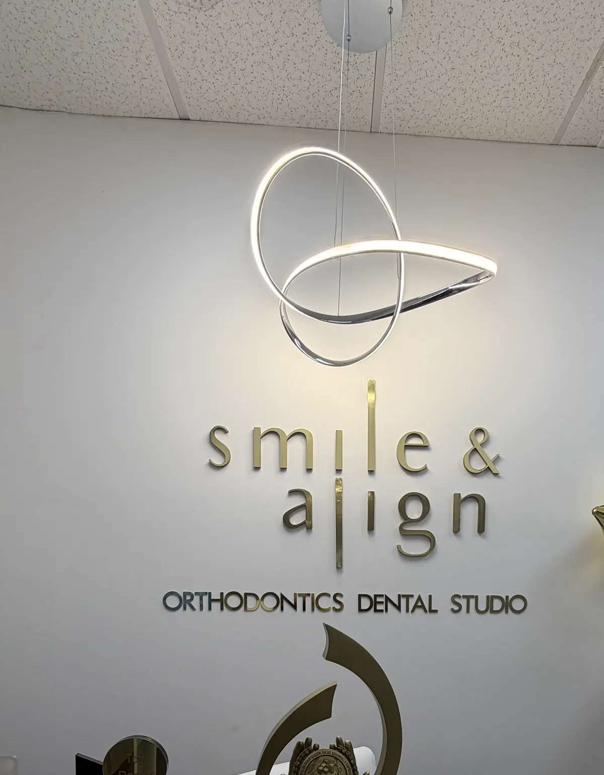 Recepción de Smile & Align, con el logo dorado en la pared